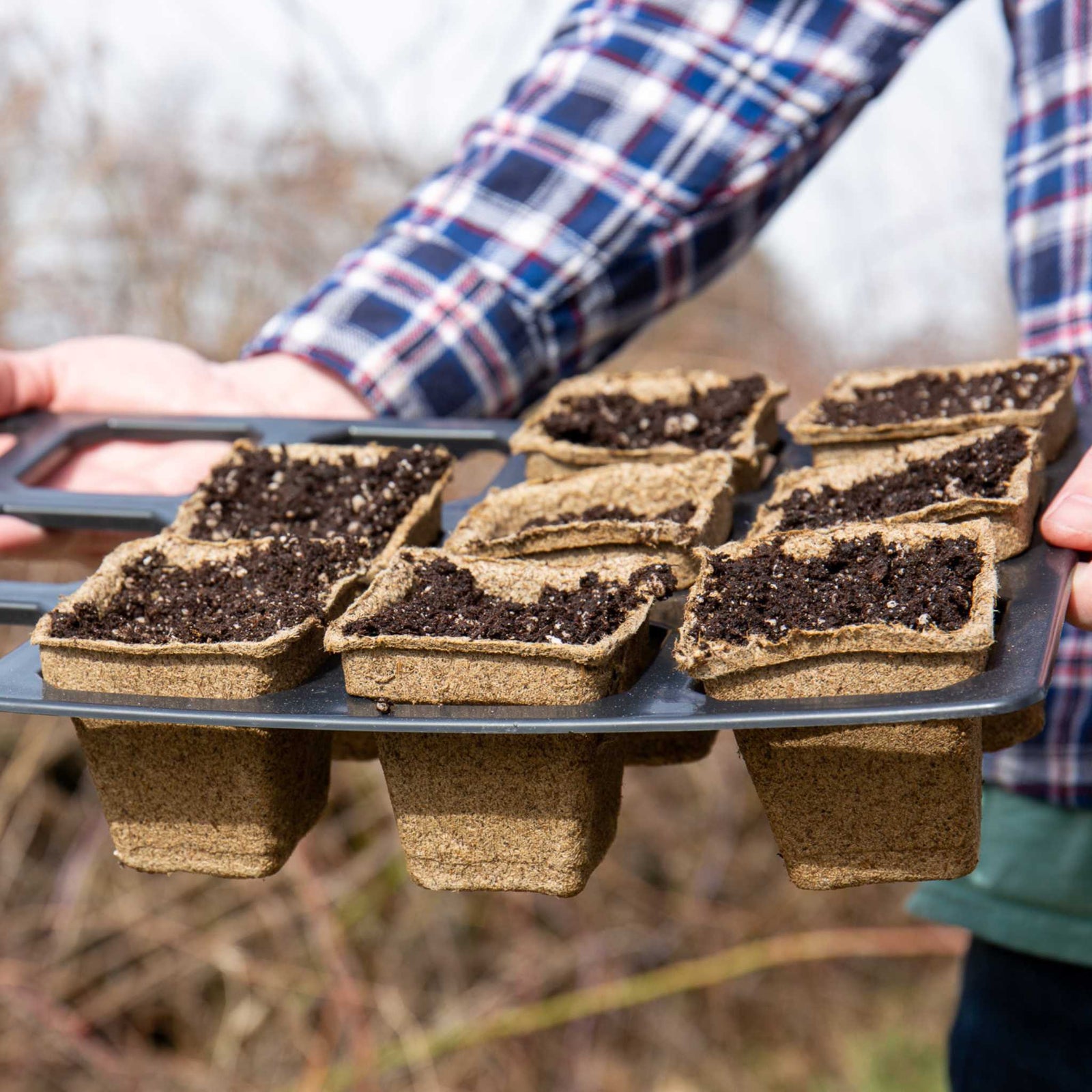 Child holding 3" square cowpots in 3.3" insert holder