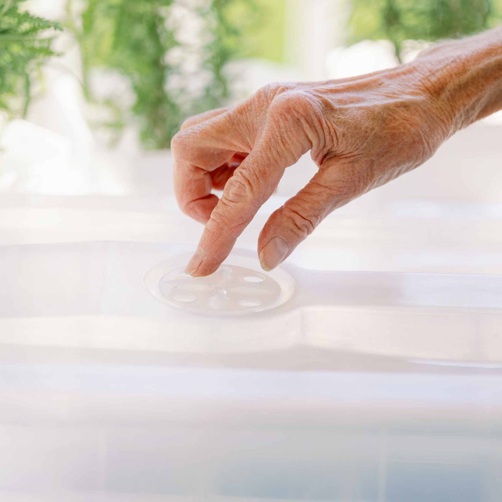 Woman closing vent on humidity dome.
