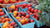 Boxes of produce sitting open. Many different types of fruits and vegetables including oranges, cherry and slicing tomatoes, salad greens, Bok choy.