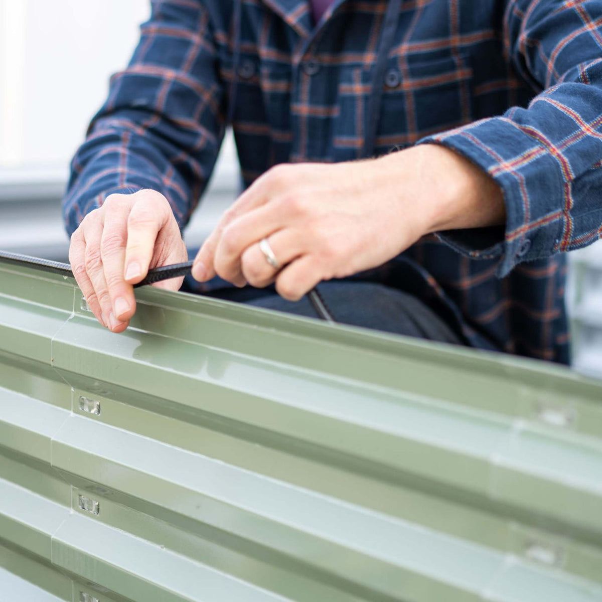 Grower installing safety edging on raised bed