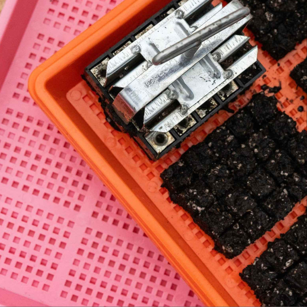 Micro20 Soil Blocker forming blocks on an orange mesh tray