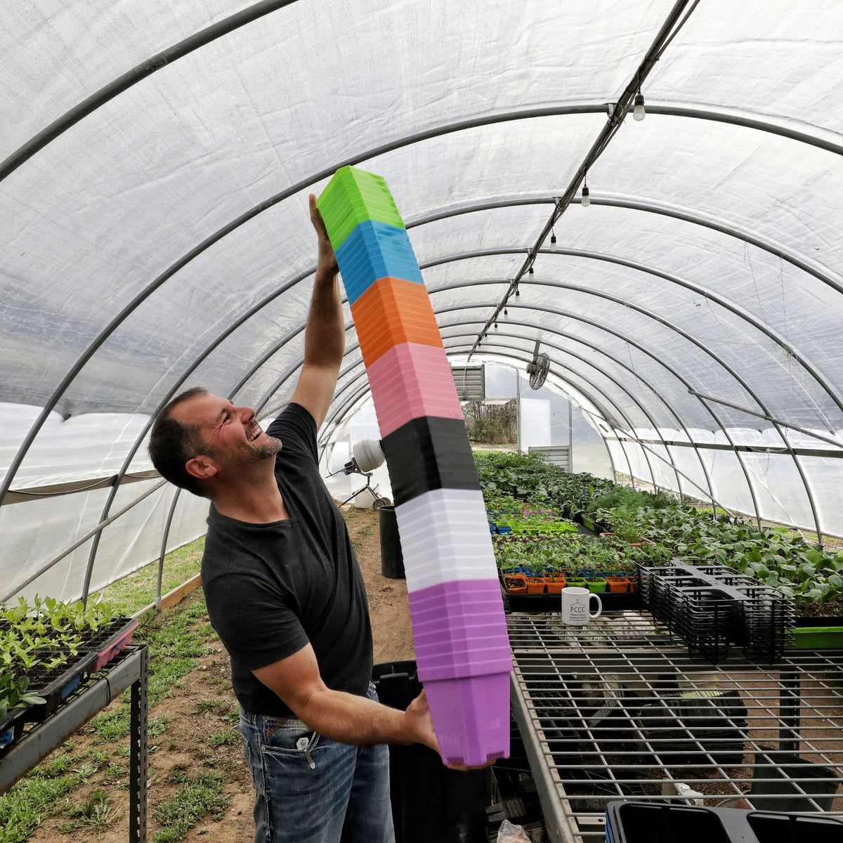 5" pots stacked with grower holding them in display