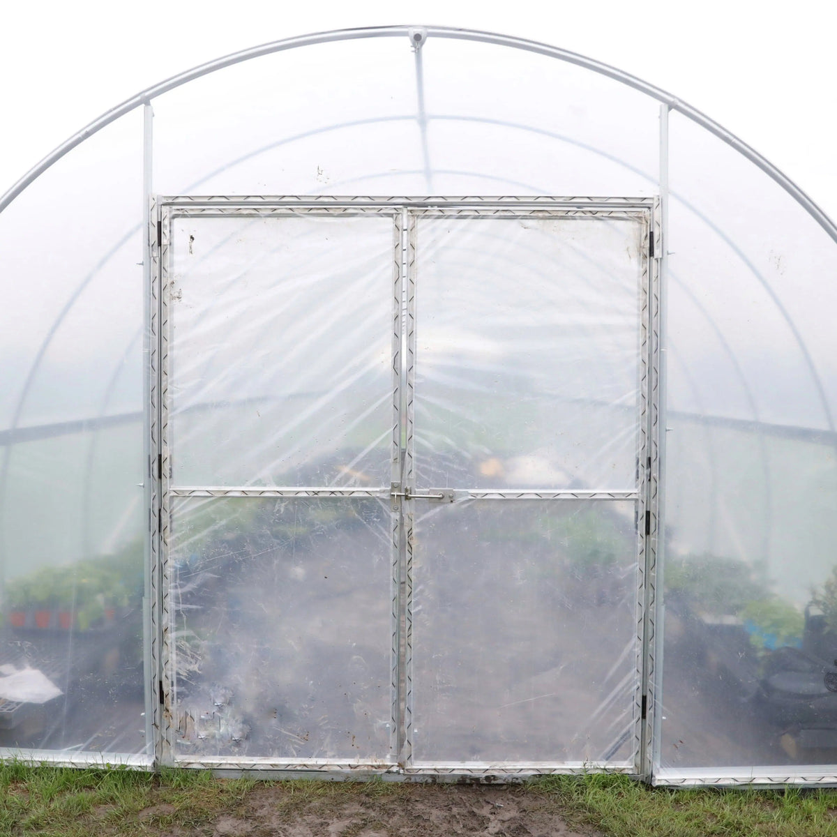 Hoop house endwall fitted with framed clear double doors